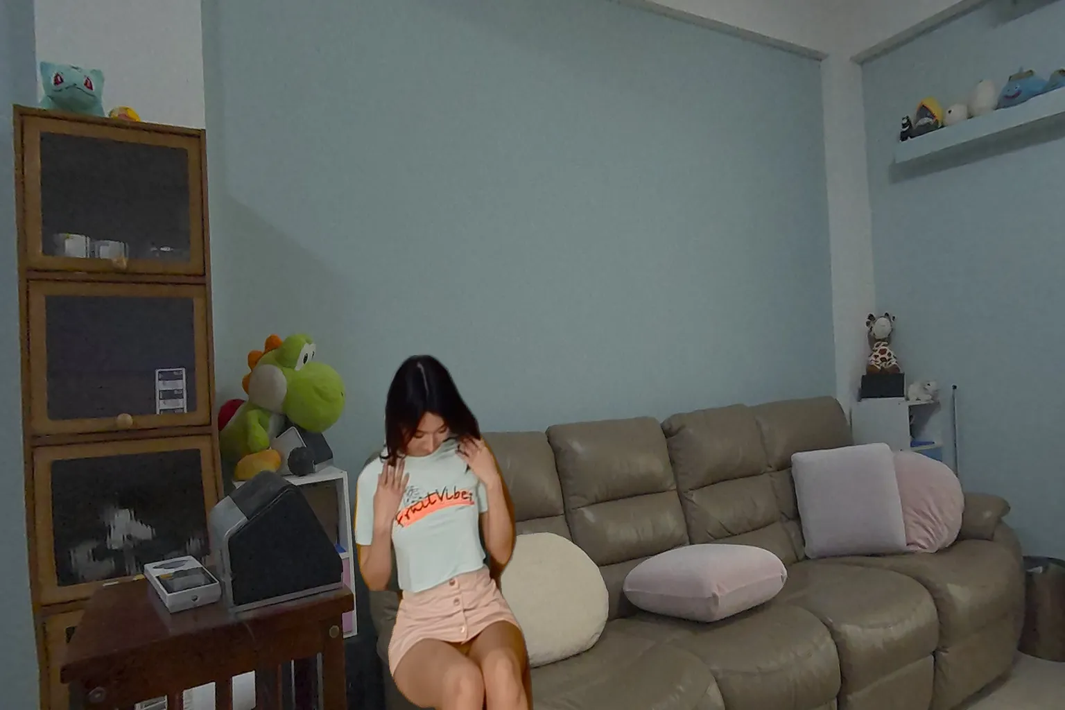 Modelo asiática con ropa informal sentada en una sala durante una escena VR
